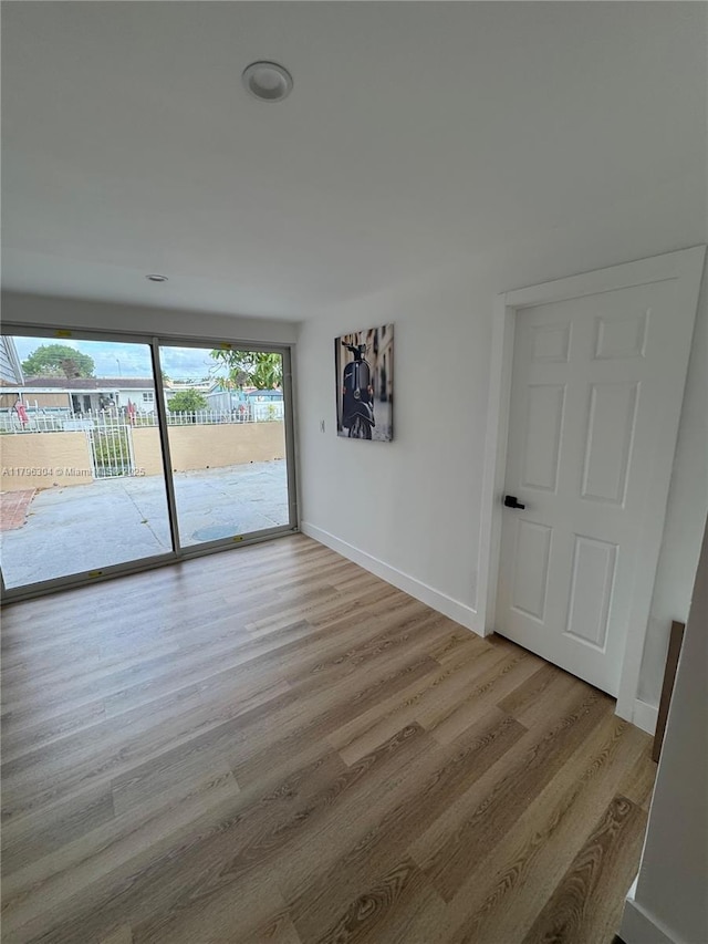 unfurnished room with baseboards and wood finished floors