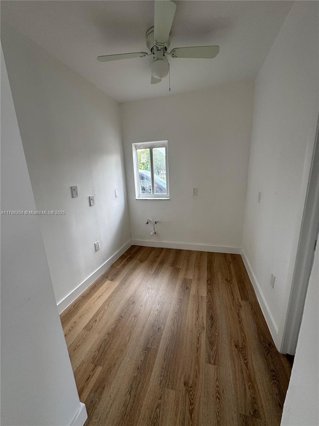 unfurnished room with a ceiling fan, baseboards, and wood finished floors