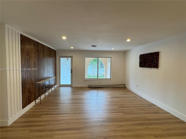 unfurnished room with recessed lighting, baseboards, visible vents, and light wood-type flooring