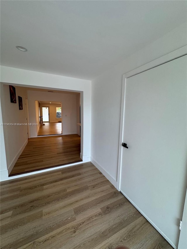 hall featuring baseboards and wood finished floors