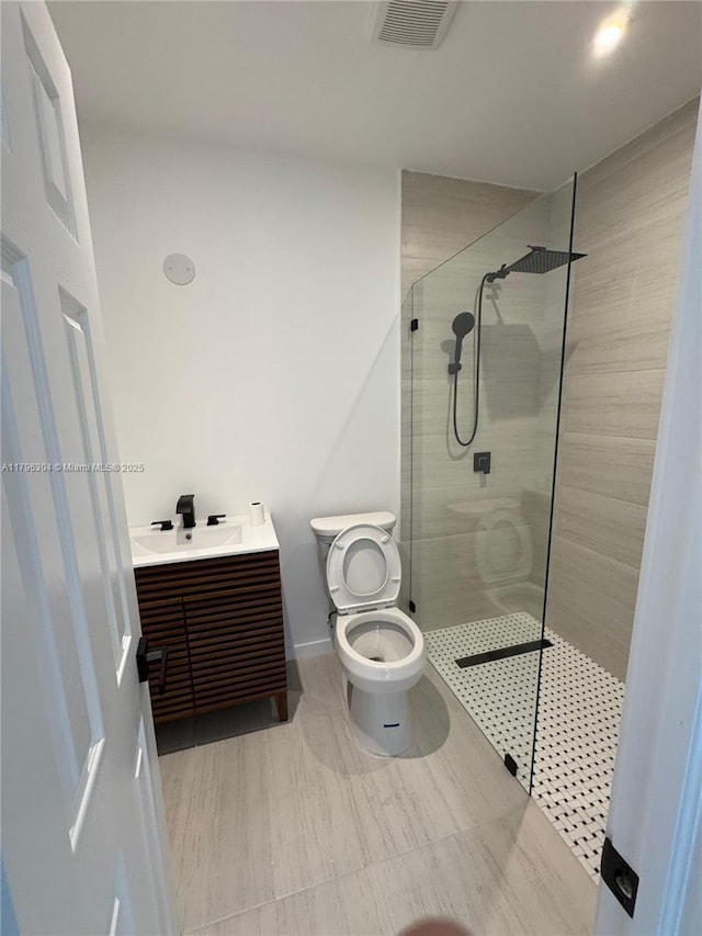 bathroom with visible vents, a walk in shower, and vanity