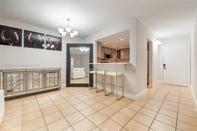 interior space featuring recessed lighting, light tile patterned floors, baseboards, and a notable chandelier
