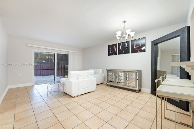 living area featuring an inviting chandelier, light tile patterned flooring, and baseboards