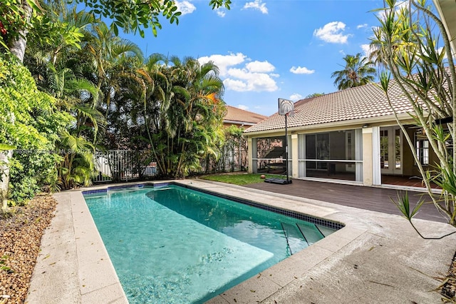 view of swimming pool with a deck, french doors, a fenced in pool, and fence