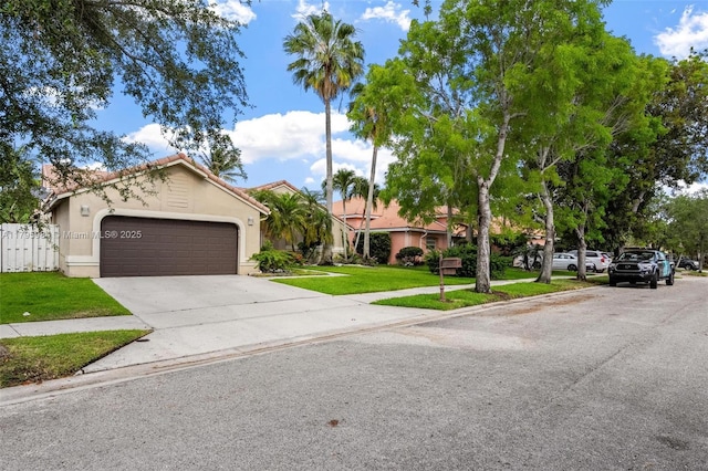 view of front facade featuring driveway, fence, a garage, stucco siding, and a front yard