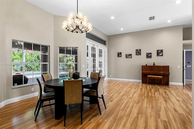 dining room featuring french doors, a notable chandelier, light wood-type flooring, visible vents, and baseboards
