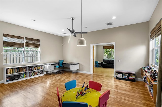 game room with ceiling fan, a wealth of natural light, baseboards, and visible vents