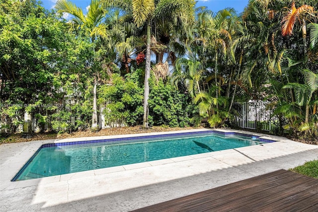 outdoor pool featuring a patio and fence