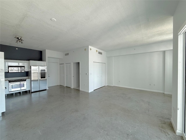 133 NE 2nd Ave Unit 1905, Miami, FL 33132 - unfurnished living room with a textured ceiling and finished concrete flooring