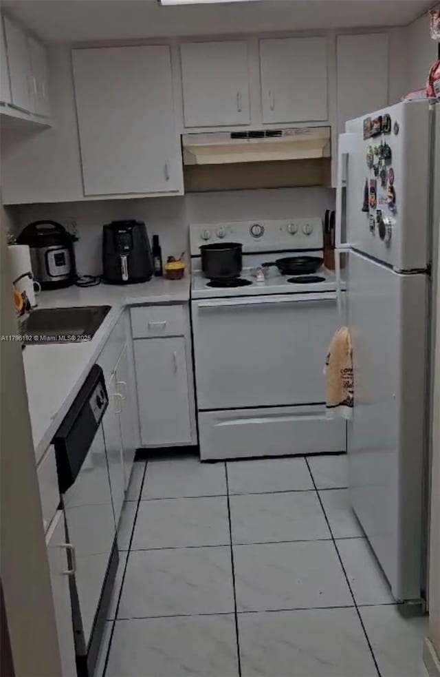 kitchen with light tile patterned floors, light countertops, under cabinet range hood, white appliances, and white cabinetry