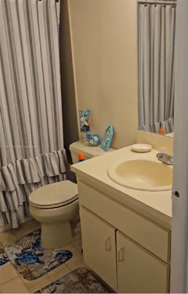bathroom featuring tile patterned flooring, toilet, and vanity