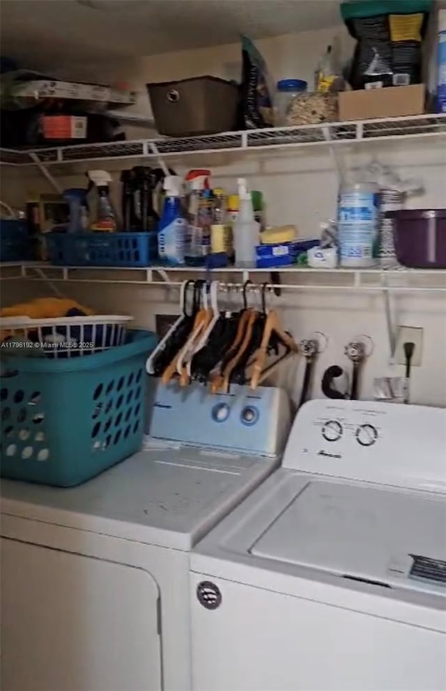 clothes washing area featuring laundry area and washer and clothes dryer