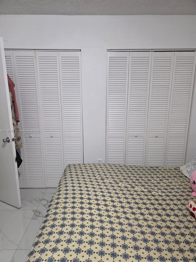6215 W 22nd Ct Unit 15, Hialeah, FL 33016 - unfurnished bedroom with light marble finish floors and multiple closets