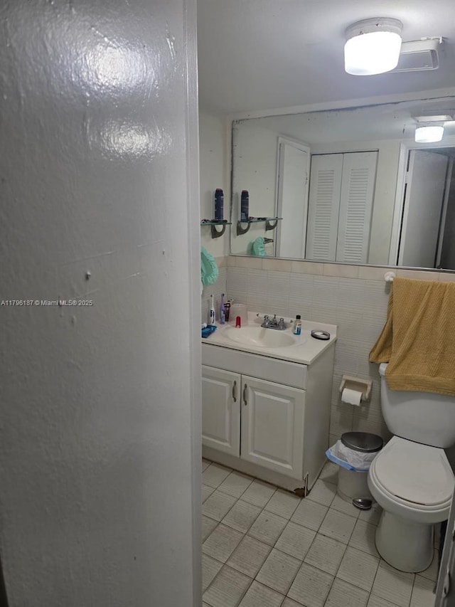 6215 W 22nd Ct Unit 15, Hialeah, FL 33016 - bathroom featuring toilet, tile patterned floors, vanity, tile walls, and tasteful backsplash