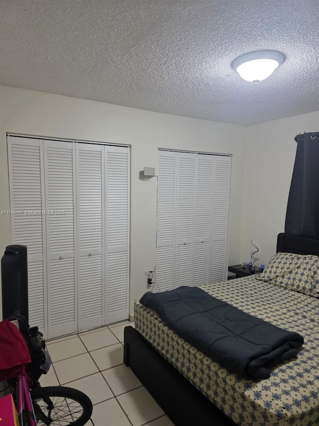 6215 W 22nd Ct Unit 15, Hialeah, FL 33016 - bedroom with two closets, a textured ceiling, and light tile patterned floors