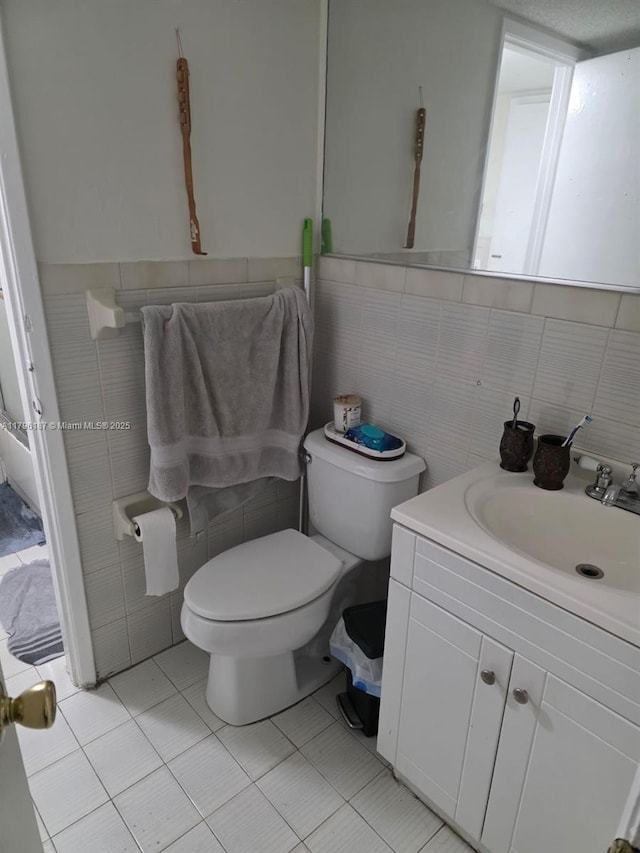 6215 W 22nd Ct Unit 15, Hialeah, FL 33016 - half bathroom featuring tile walls, toilet, vanity, and wainscoting