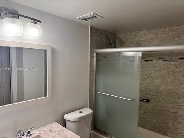 full bath with visible vents, combined bath / shower with glass door, and toilet