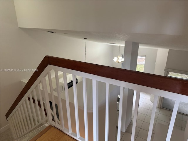 stairs with an inviting chandelier