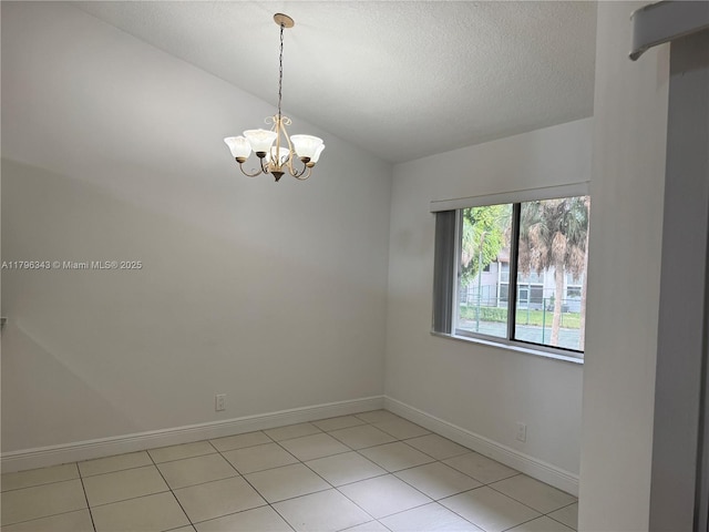 unfurnished room with light tile patterned flooring, baseboards, a notable chandelier, and a textured ceiling