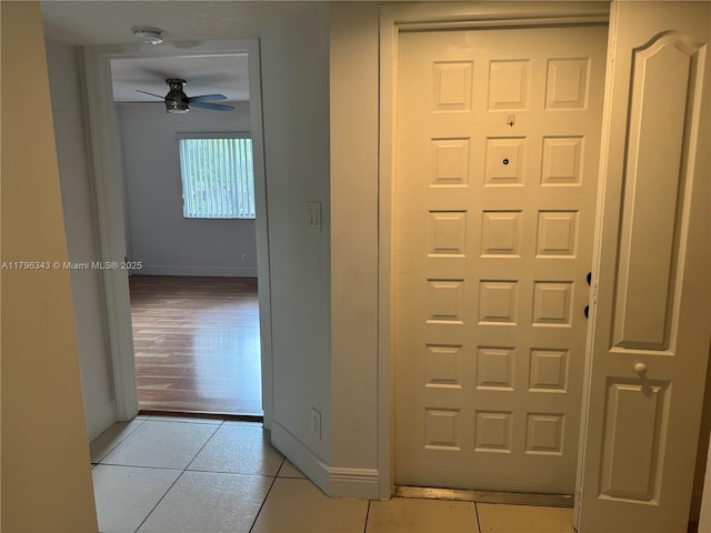 interior space with baseboards and light tile patterned flooring
