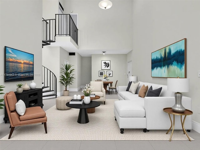tiled living room with baseboards, stairway, and a towering ceiling