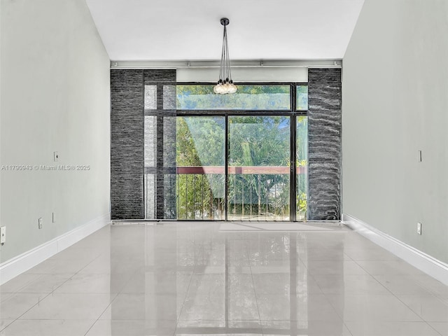 unfurnished dining area featuring baseboards, floor to ceiling windows, and tile patterned flooring