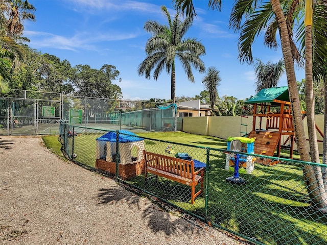 view of home's community with a gate, playground community, fence, and a yard