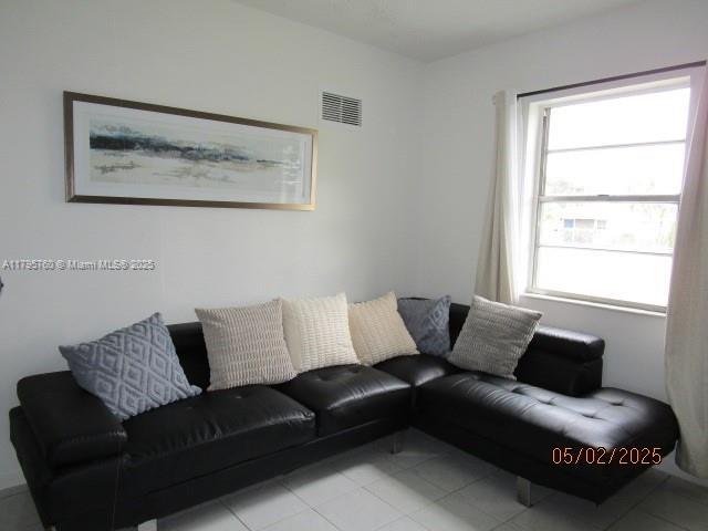 living area featuring light tile patterned floors and visible vents