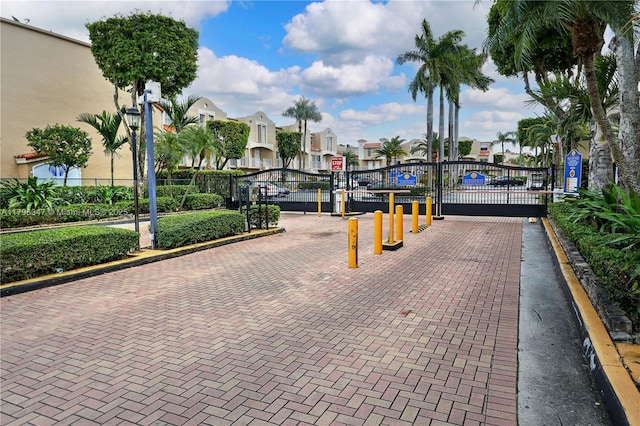 exterior space featuring a gate, fence, and a residential view