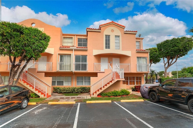 view of building exterior featuring uncovered parking and stairs