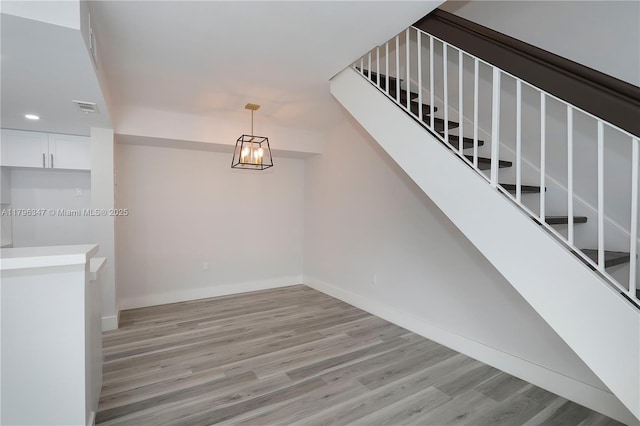 staircase featuring visible vents, wood finished floors, baseboards, and recessed lighting