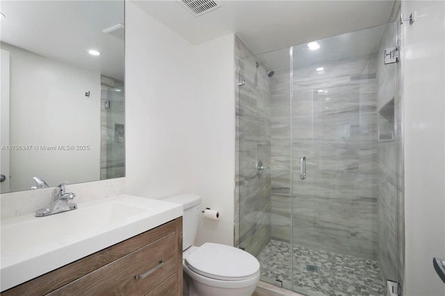 bathroom featuring toilet, vanity, visible vents, recessed lighting, and a shower stall