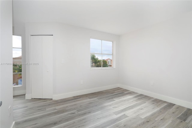 unfurnished room featuring light wood finished floors and baseboards