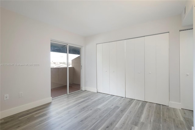 unfurnished bedroom with baseboards, visible vents, and wood finished floors