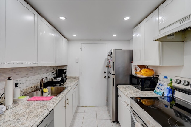 2350 NE 135th St Unit 510, North Miami, FL 33181 - kitchen with appliances with stainless steel finishes, exhaust hood, white cabinetry, backsplash, and recessed lighting