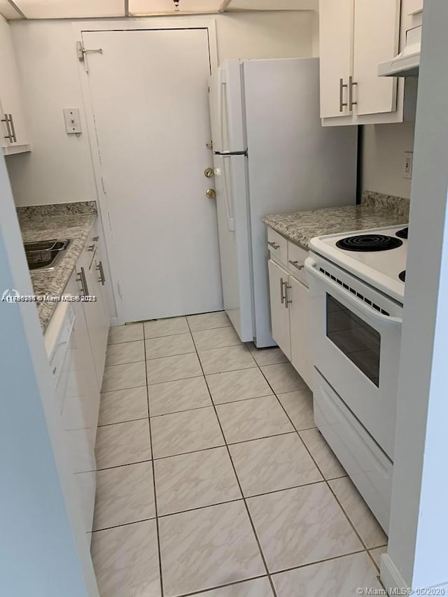 2350 NE 135th St Unit 510, North Miami, FL 33181 - kitchen with light tile patterned floors, light countertops, white range with electric stovetop, and white cabinets