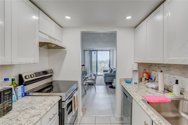 2350 NE 135th St Unit 510, North Miami, FL 33181 - kitchen featuring appliances with stainless steel finishes, under cabinet range hood, white cabinets, backsplash, and recessed lighting