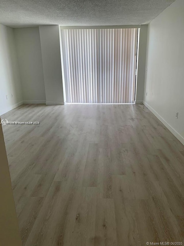 2350 NE 135th St Unit 510, North Miami, FL 33181 - empty room with a textured ceiling, baseboards, and wood finished floors