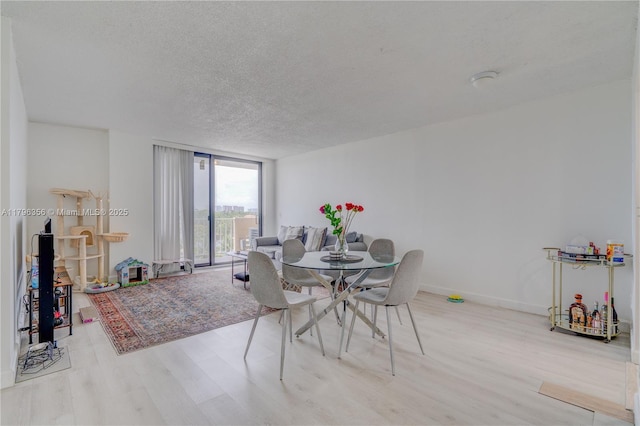 2350 NE 135th St Unit 510, North Miami, FL 33181 - dining room with wood finished floors, expansive windows, and a textured ceiling