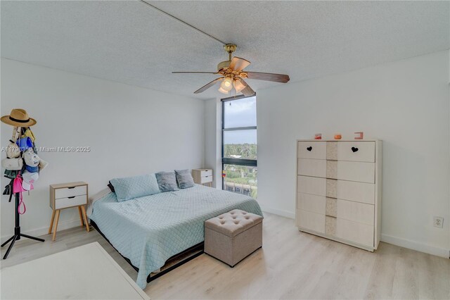 2350 NE 135th St Unit 510, North Miami, FL 33181 - bedroom with wood finished floors, a ceiling fan, and a textured ceiling