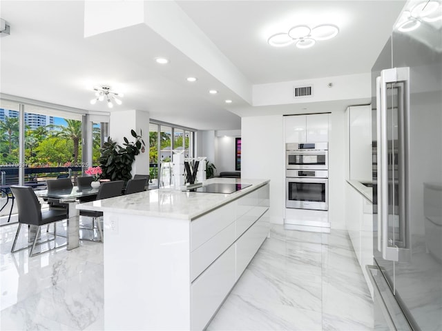 kitchen featuring recessed lighting, a center island, modern cabinets, visible vents, and white cabinetry