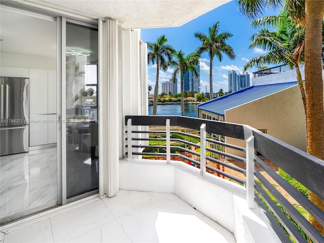 balcony with a water view and a view of city