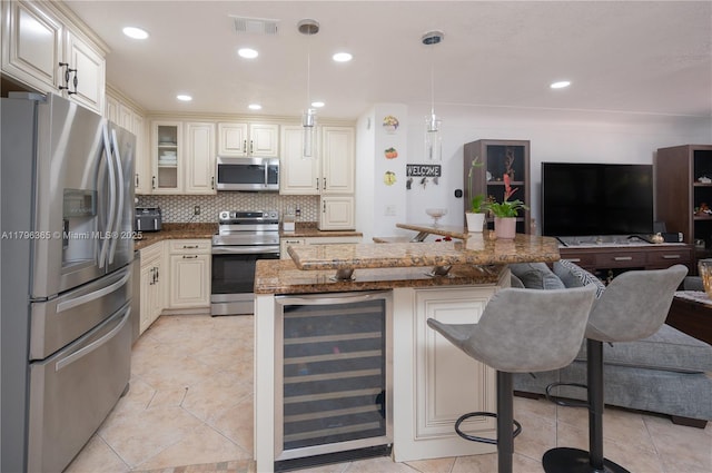 717 E River Dr, Margate, FL 33063 - kitchen with stainless steel appliances, wine cooler, open floor plan, a kitchen breakfast bar, and backsplash