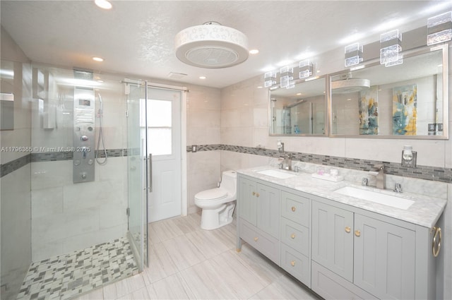 717 E River Dr, Margate, FL 33063 - bathroom featuring a shower stall, double vanity, toilet, tile walls, and tile patterned flooring