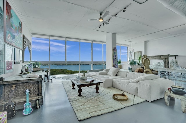 living area with finished concrete flooring, a water view, ceiling fan, and expansive windows