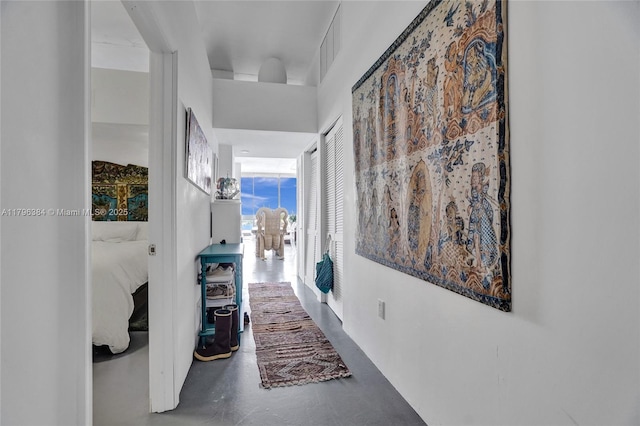 hallway featuring visible vents and finished concrete flooring