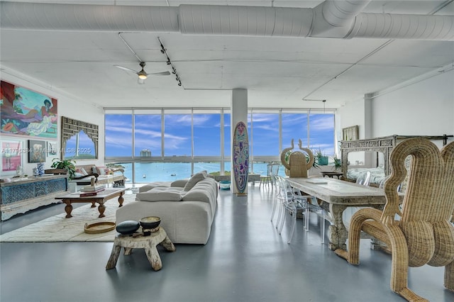 living area with a wall of windows, a water view, finished concrete flooring, and a wealth of natural light