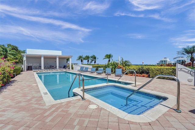 community pool with a hot tub and a patio