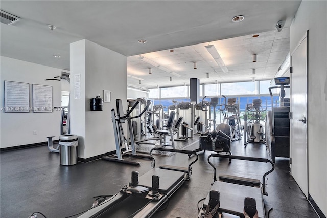 workout area with a wall of windows, baseboards, and visible vents