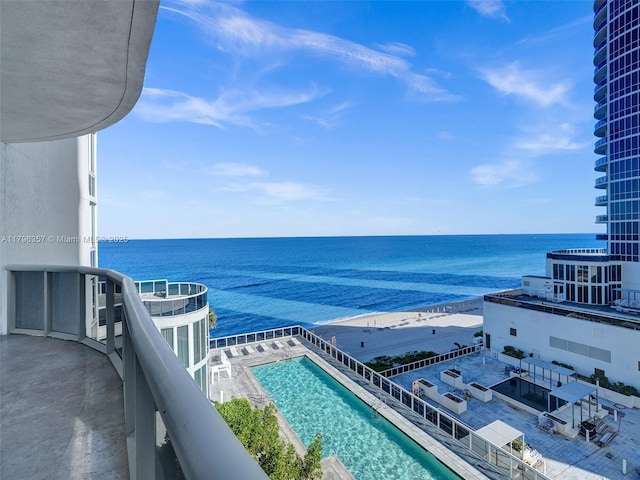 balcony featuring view of pool and a water view